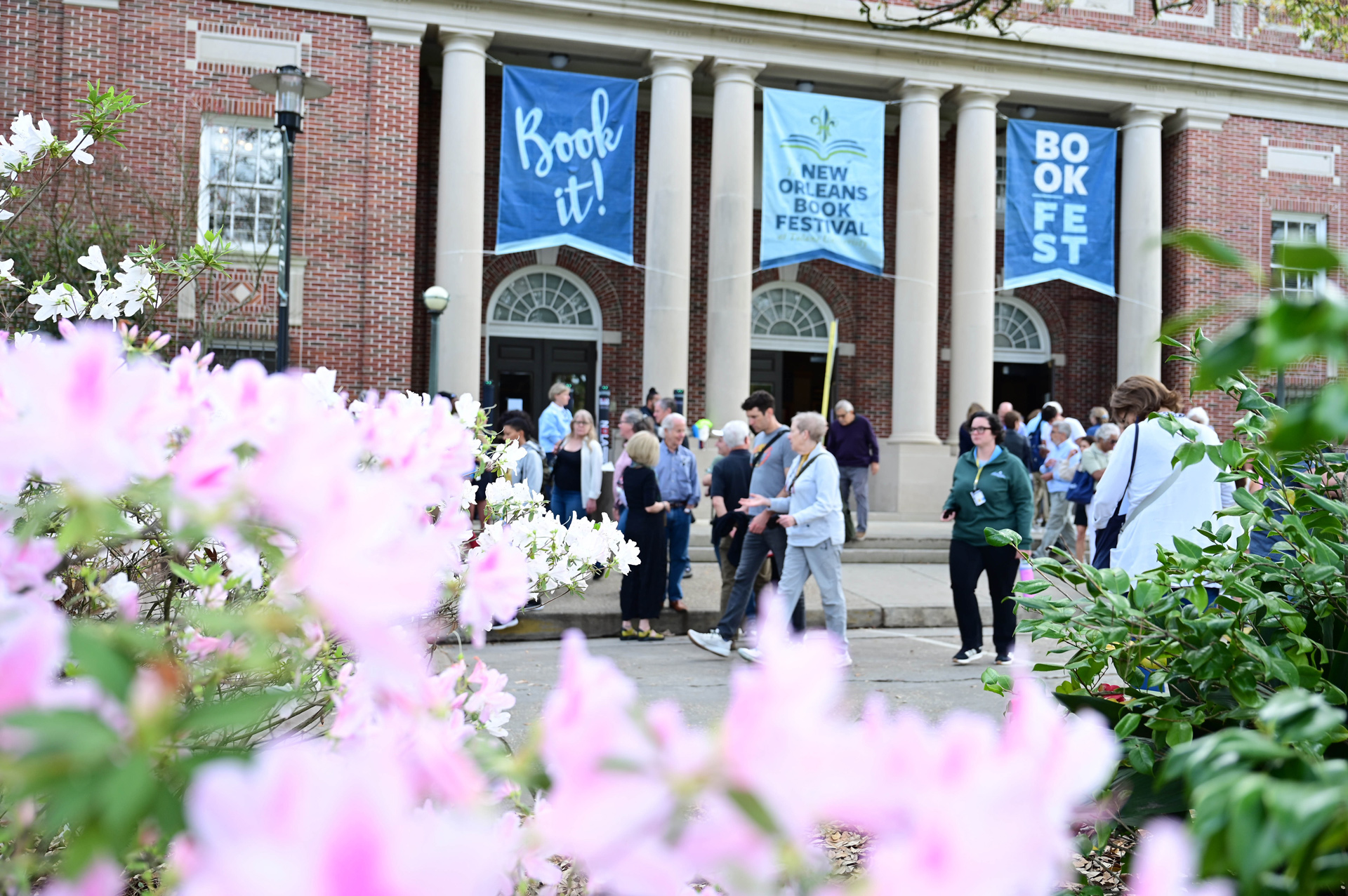 Book Festival | Crowd gathers at the New Orleans Book Festival, framed by pink flowers.
