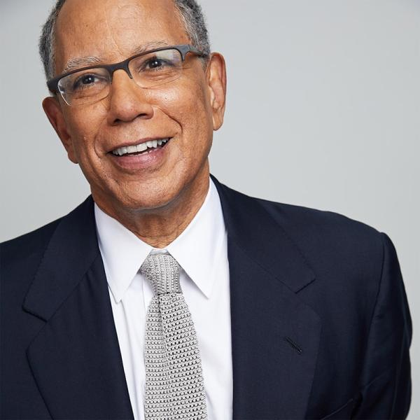Portrait of Dean Baquet in a suit jacket and tie