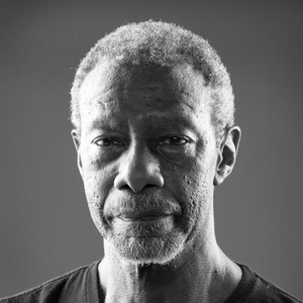 Black and white portrait of an older Black man with a serious expression.