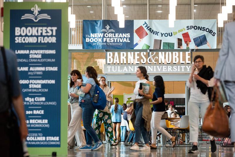Attendees at the 2024 New Orleans Book Festival walking past signage that says "Thank You Sponsors"