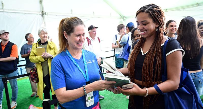 Festival volunteer helps attendee at the 2025 New Orleans Book Festival. Festival volunteer helps attendee at the 2025 New Orleans Book Festival.