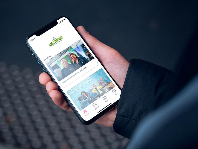 Hand holding a mobile device showing the New Orleans Book Festival digital guide on the Bloomberg Connects app