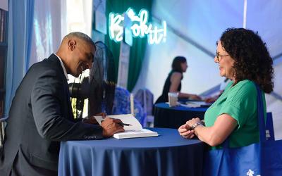 Chef Edgar "Dook" Chase IV shares a moment with an attendee while signing books at the 2024 New Orleans Book Festival at Tulane University.